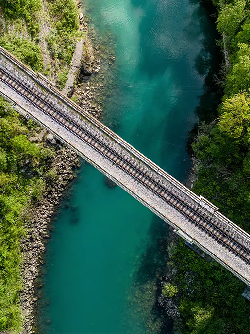 Bird's eye view of railroad tracks crossing a river bridge
