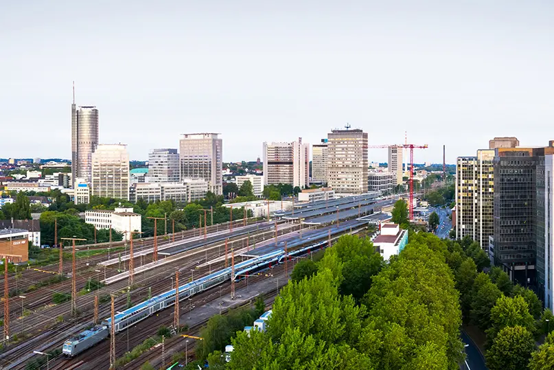 Train station with many railroad tracks, a train and some skyscrapers in Germany